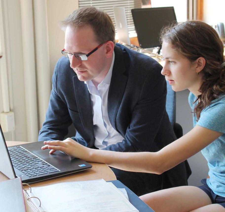 Faculty working with student at laptop