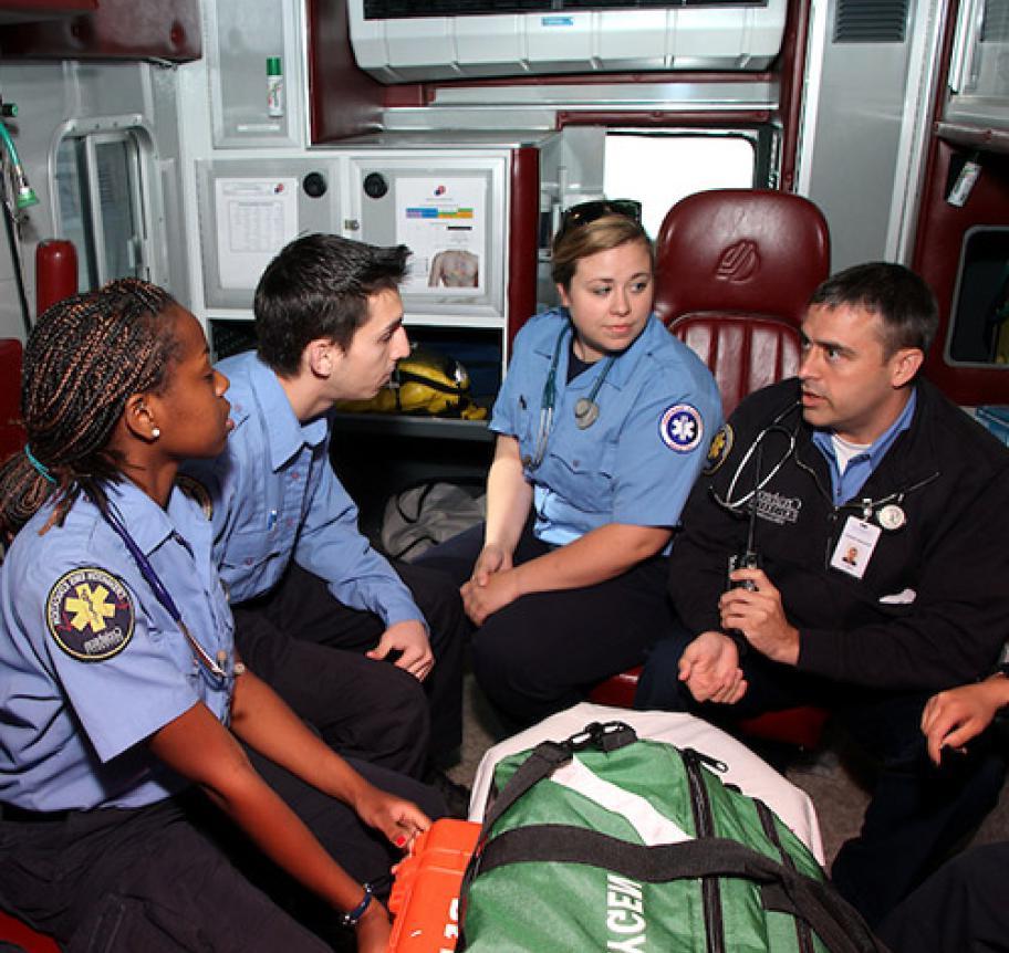 护理人员 students listening to their instructor in the back of an ambulance